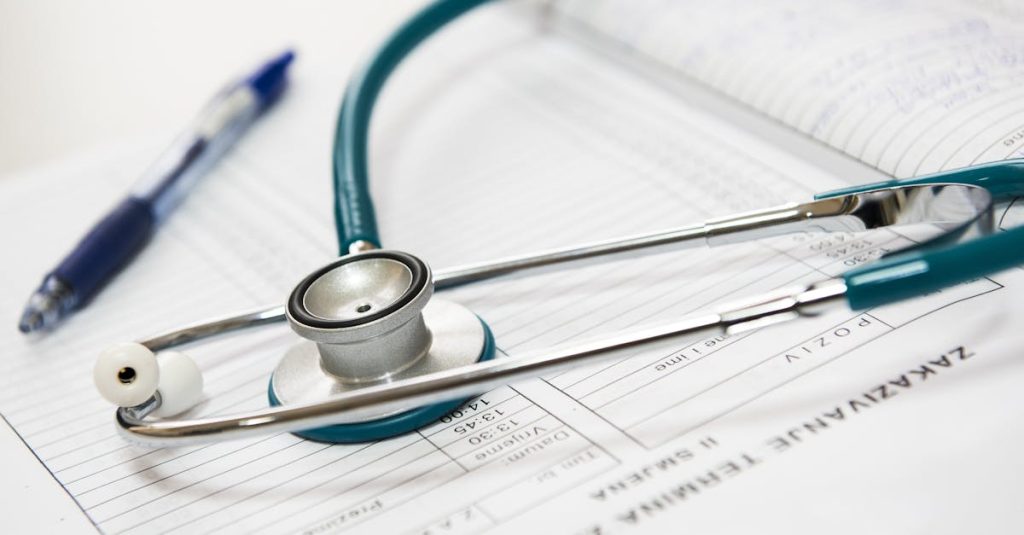 A stethoscope and pen resting on a medical report in a healthcare setting.