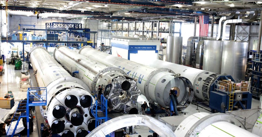 View of a spacecraft assembly line with rockets in a spacious hangar.