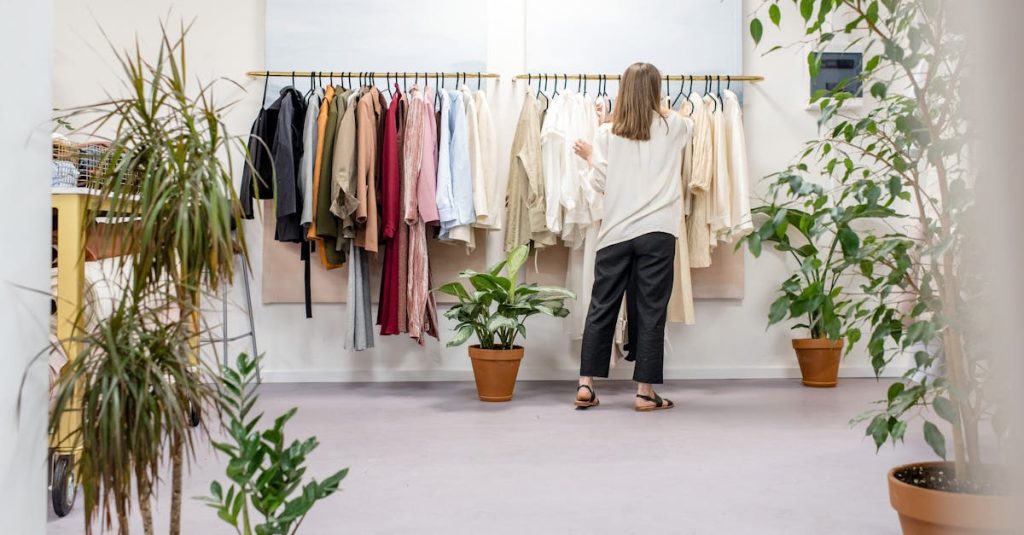 Woman browsing clothes in a boutique surrounded by indoor plants and stylish displays. Ideal fashion retail scene.